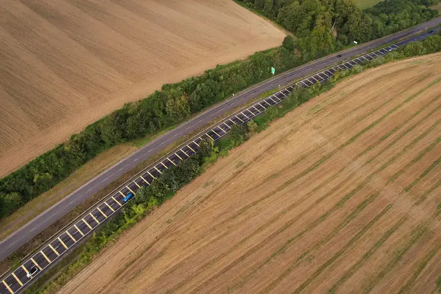 A main road running through flat farmland seen from above, the sort of route the A570 follows between Southport and Ormskirk