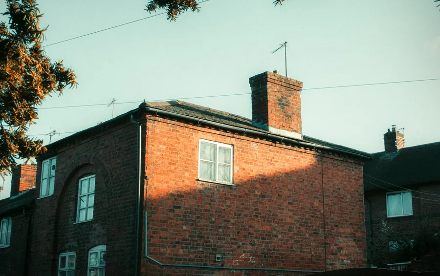 Brick chimney stack with lead flashing where it meets the roof, the usual source of chimney breast damp in Southport