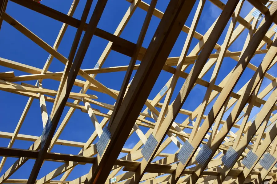 Trussed roof timbers and nail plates seen from below, the sort of structural design building control checks before a solid conservatory roof in Southport