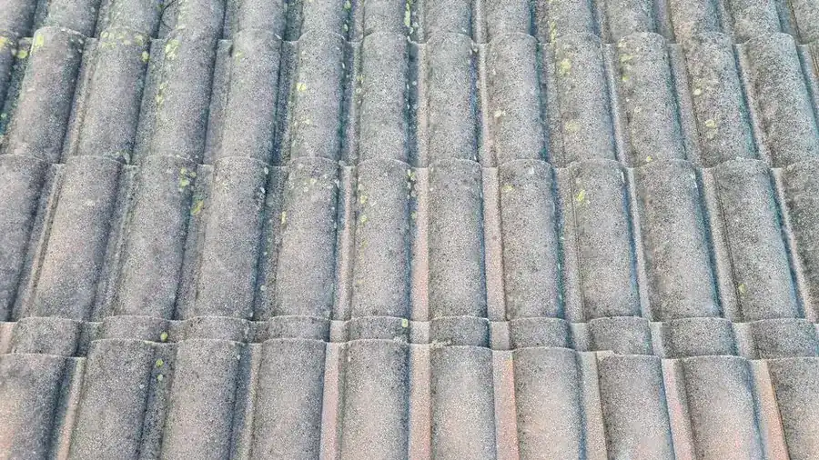 Weathered concrete interlocking roof tiles with lichen growth, typical of 1960s and 1970s Southport bungalows