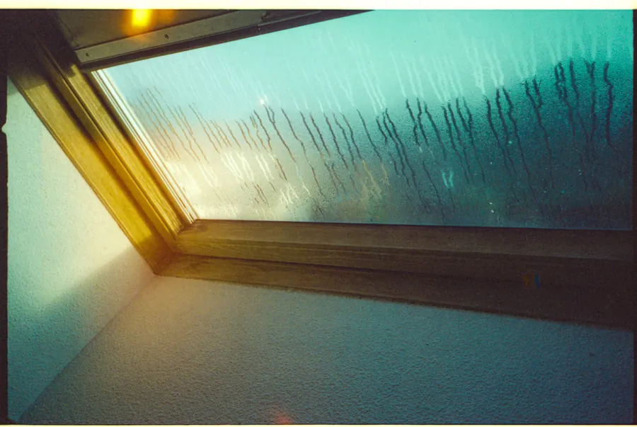 Condensation running down the inside of a roof window in a cold loft, a common Southport complaint mistaken for a leak