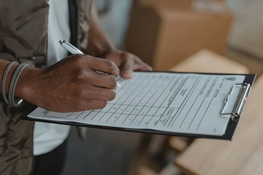 Contractor completing a written itemised checklist on a clipboard before starting work