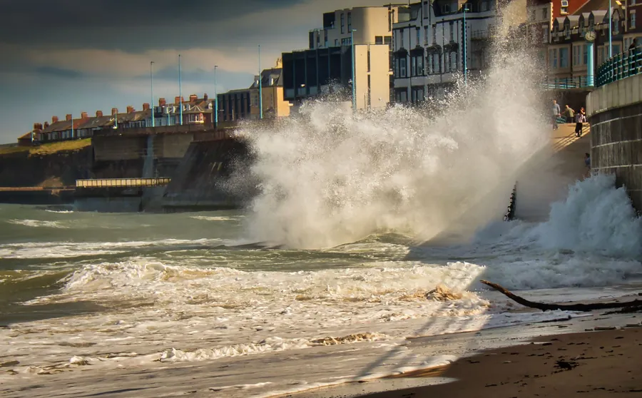 Waves breaking over a seafront during an Irish Sea storm, the conditions that test Southport roofs every winter