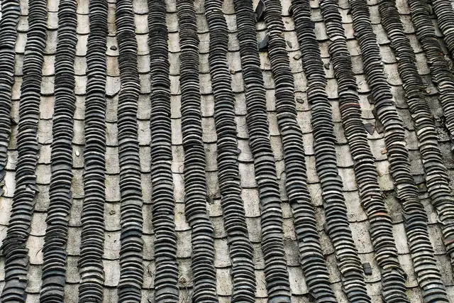 Close-up of natural slates laid in courses, the kind of surface a grading code is describing