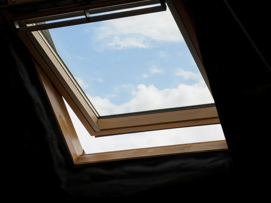 Open roof window with bright sky above, showing the daylight a Southport loft gains from a window in the roof plane