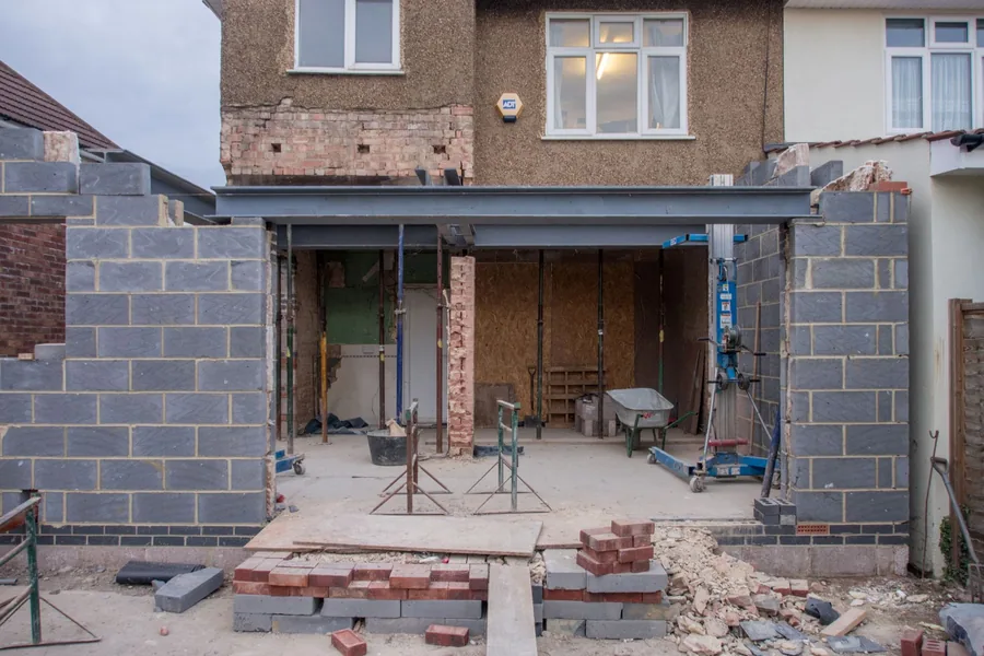 British house mid-renovation with structural work in progress, illustrating sequencing major building jobs together