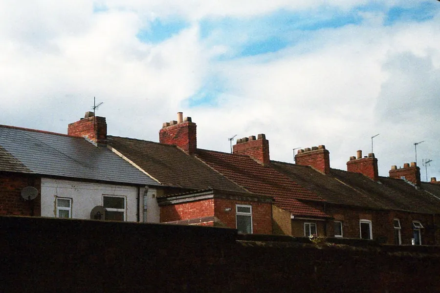 Terrace rooflines and chimney stacks viewed from ground level while checking a Southport roof for slipped tiles