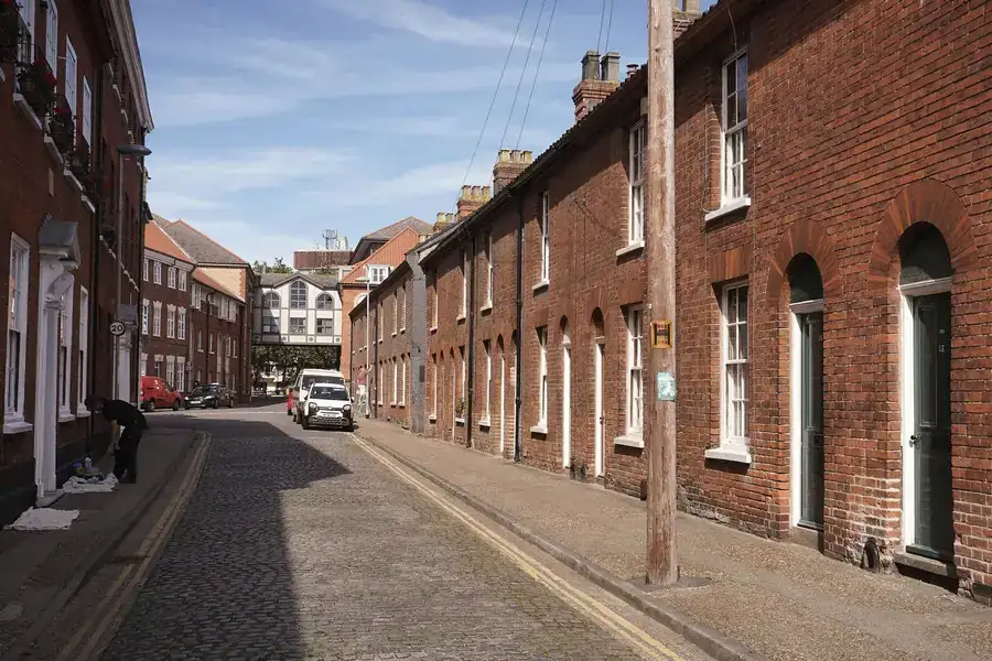 A row of red brick terraced houses on an English street, the type of Ormskirk housing that has become student lets near Edge Hill University