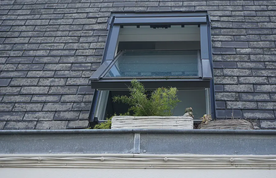 Roof window set into a natural slate roof with its flashing kit visible around the frame, the detail that keeps a Southport slate roof watertight