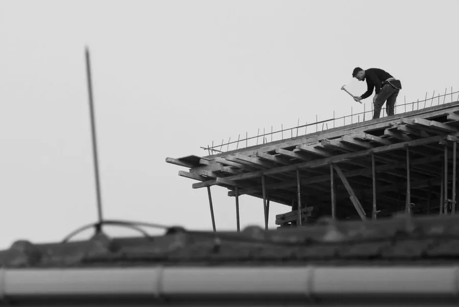 Roofer working at height at the edge of a roof, where access decides a large part of a Southport roof repair cost