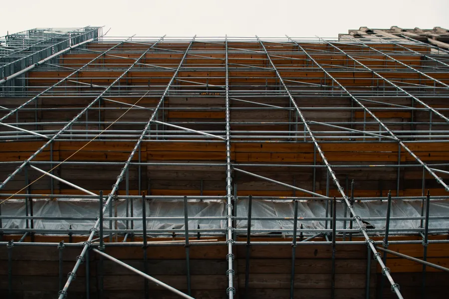 Tube and board scaffolding sheeted up the side of a building, the first and one of the largest lines on a Southport re-roof quote