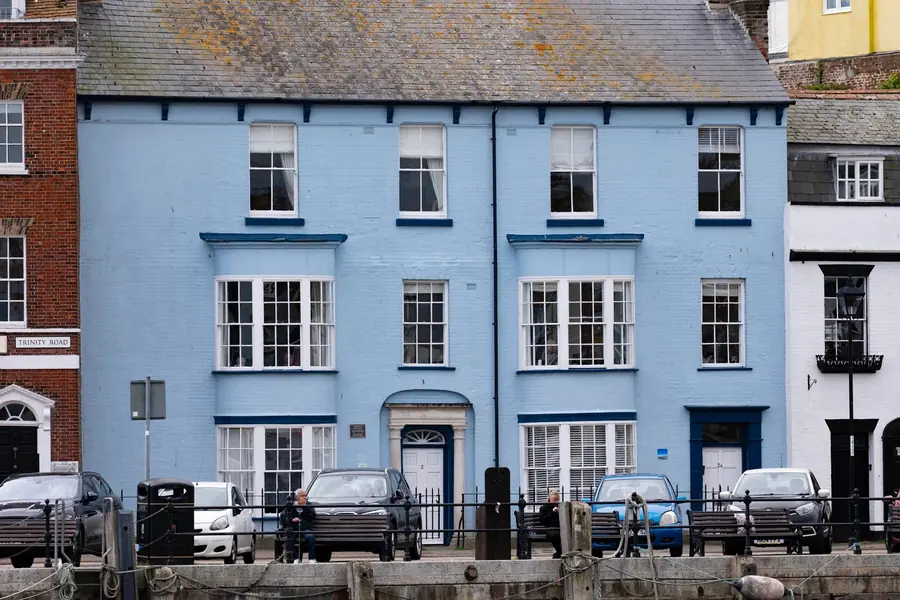 Painted seafront terrace with slate roof, timber fascia brackets and a cast downpipe of the kind maintained in Southport