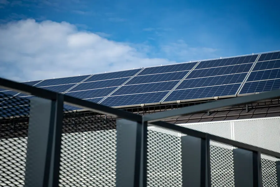 Solar panels mounted on rails above a pitched roof, showing the mounting system that fixes into the roof structure