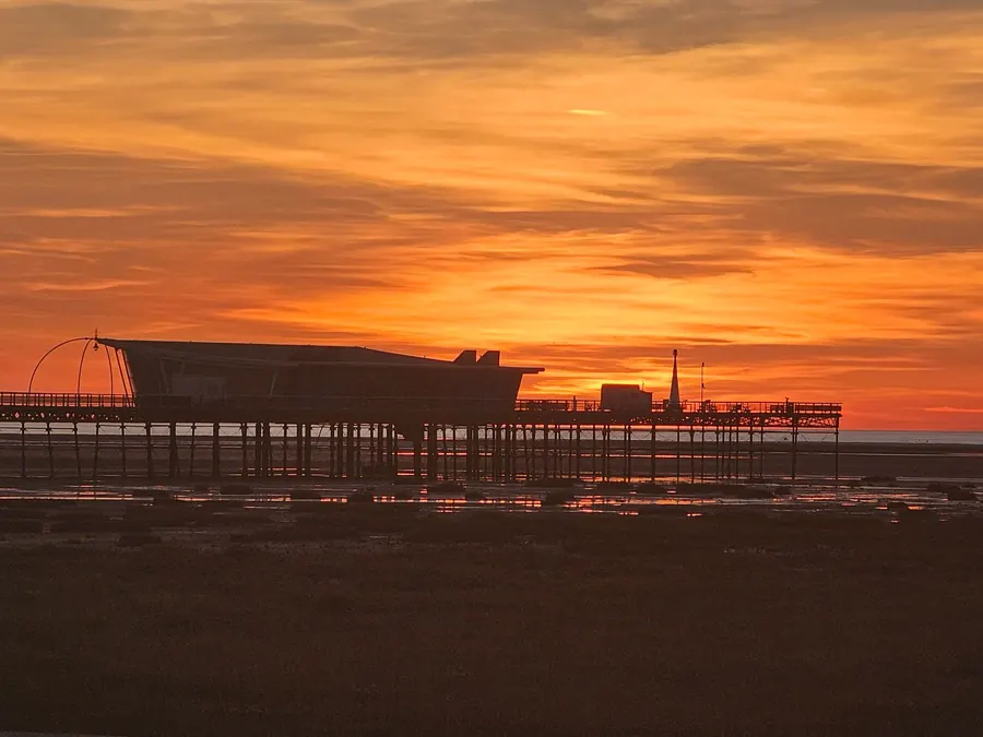 Sunset over Southport Pier and the Irish Sea, the western exposure that heats and cools lead on the town's roofs