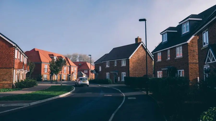 Suburban English street of brick houses with shallow hipped tiled roofs