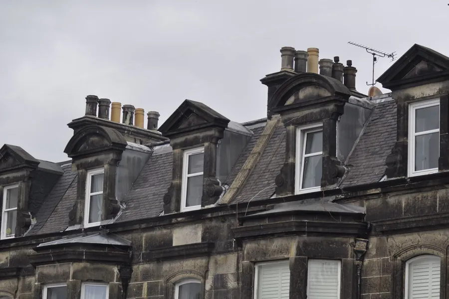 Victorian dormers and slate roofs on a terrace, the type of exposed roofline that ages fastest near the coast
