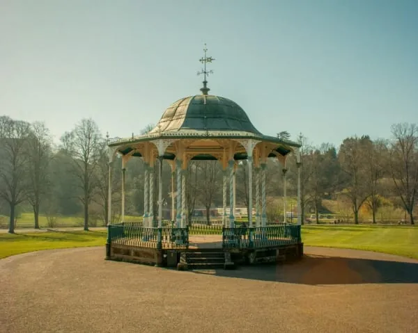 An ornate park bandstand among trees and lawns, the centrepiece of Coronation Park in Ormskirk