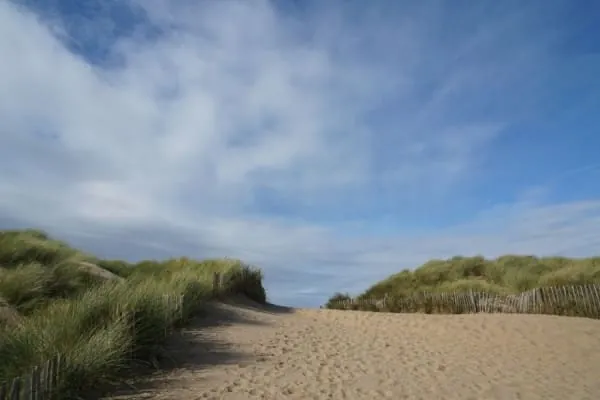 A sandy path between fenced dunes leading down to Formby beach