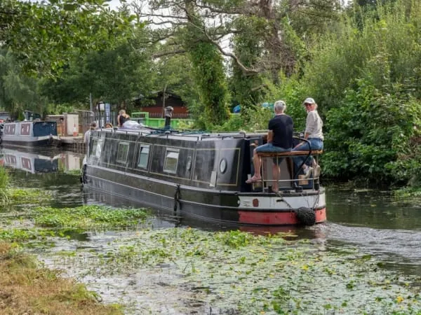 A narrowboat cruising the tree-lined Leeds and Liverpool Canal as it does through Maghull