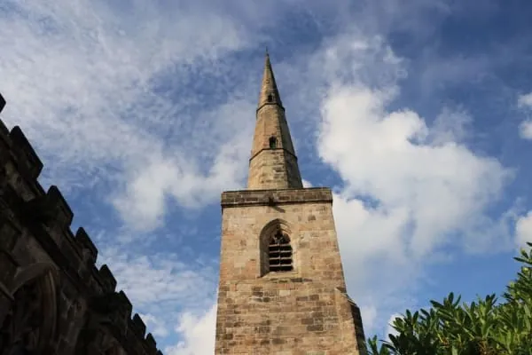 A historic stone church displaying both a tower and a spire, Ormskirk parish church's famous combination