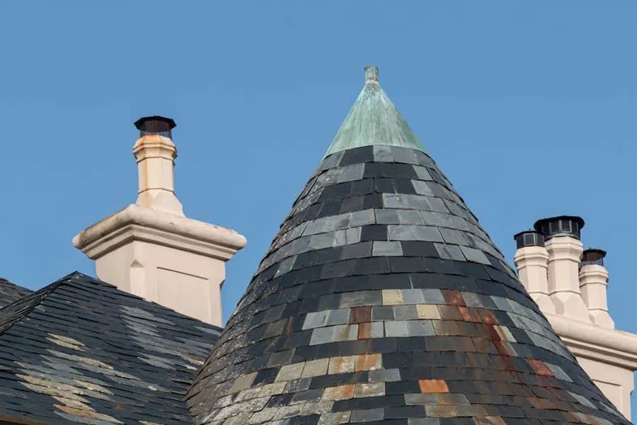 Close-up of a brick chimney and tiled roof junction where lead flashing is required