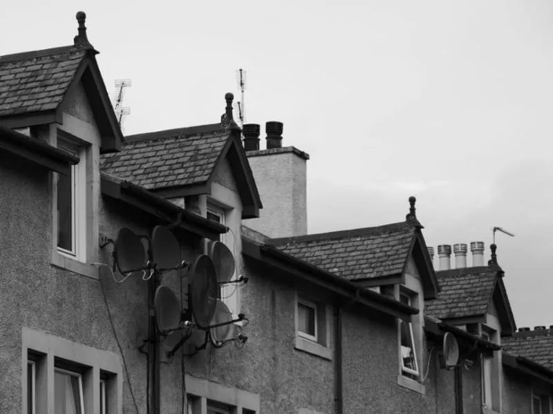 Dormers and chimney stacks along a steep terraced roofline like Ormskirk's town centre streets
