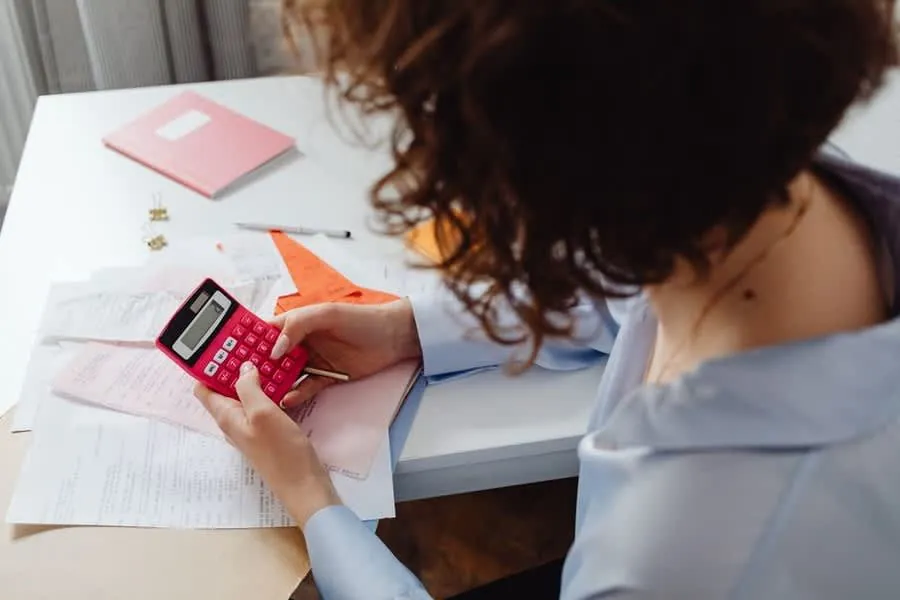 Landlord working through property maintenance costs with a calculator and paperwork