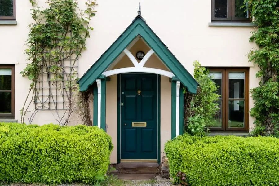 Traditional British house entrance with a small canopy roof over the front door
