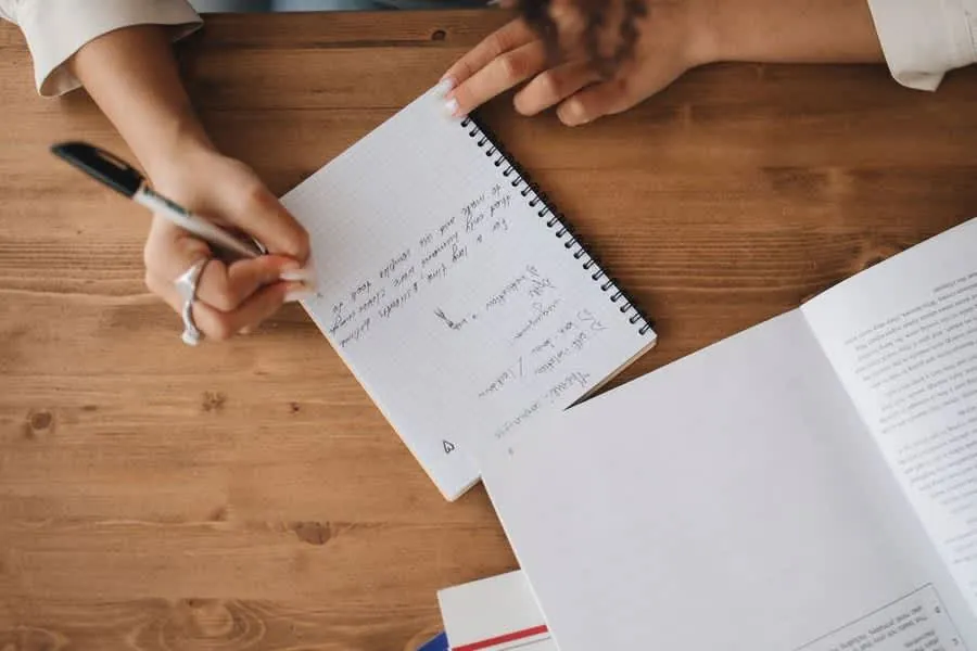 Homeowner writing notes while comparing roofing quotes