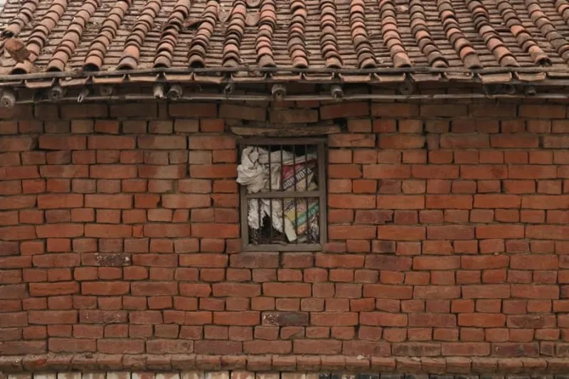 A roof abutment where a slate slope meets a brick wall, the junction that fails first in Ormskirk