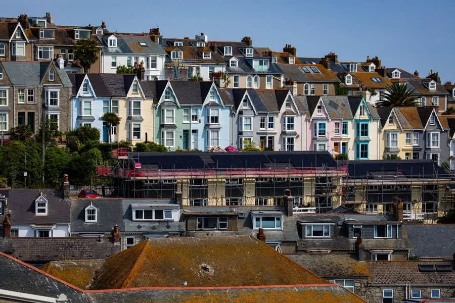 Scaffolding erected on a row of British terraced houses for roof and chimney work
