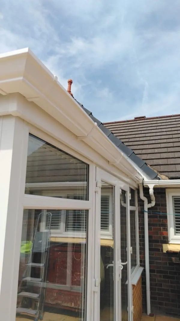 New guttering and downpipe with lead flashing where a lower roof abuts the main roof in Southport