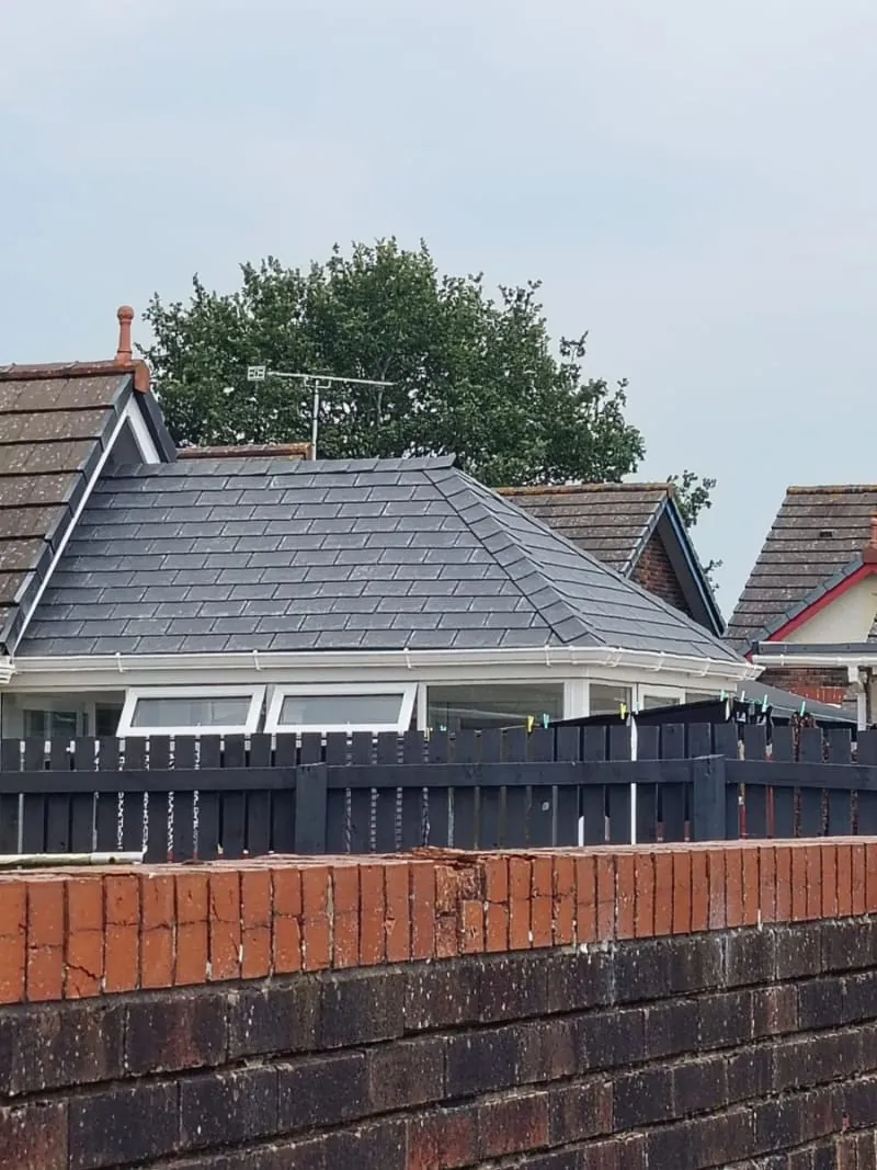 Completed hipped roof in dark slate-grey tiles with new white fascia and guttering on a Southport bungalow