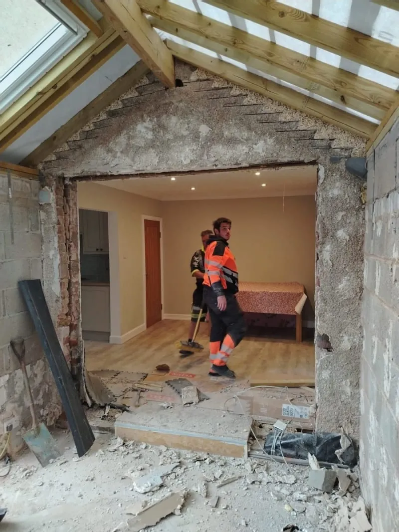 Roofers working on site under a newly built roof structure with roof windows in Southport