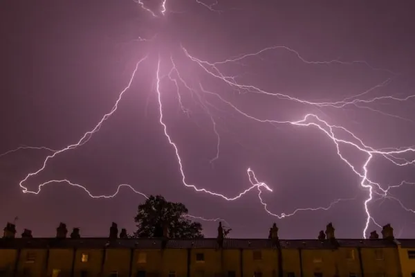 Lightning breaking over rooftops during the storms that sweep the open mosses