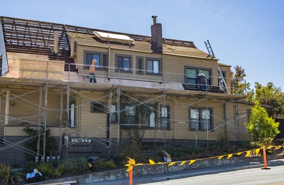 Roofer carrying out a slate repair on a pitched roof in Southport
