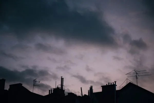 Dark storm clouds gathering over rooftops, the weather that damages Southport roofs